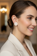 White woman wearing Pillow Talk Stud Earrings with stud post aligned with earlobe